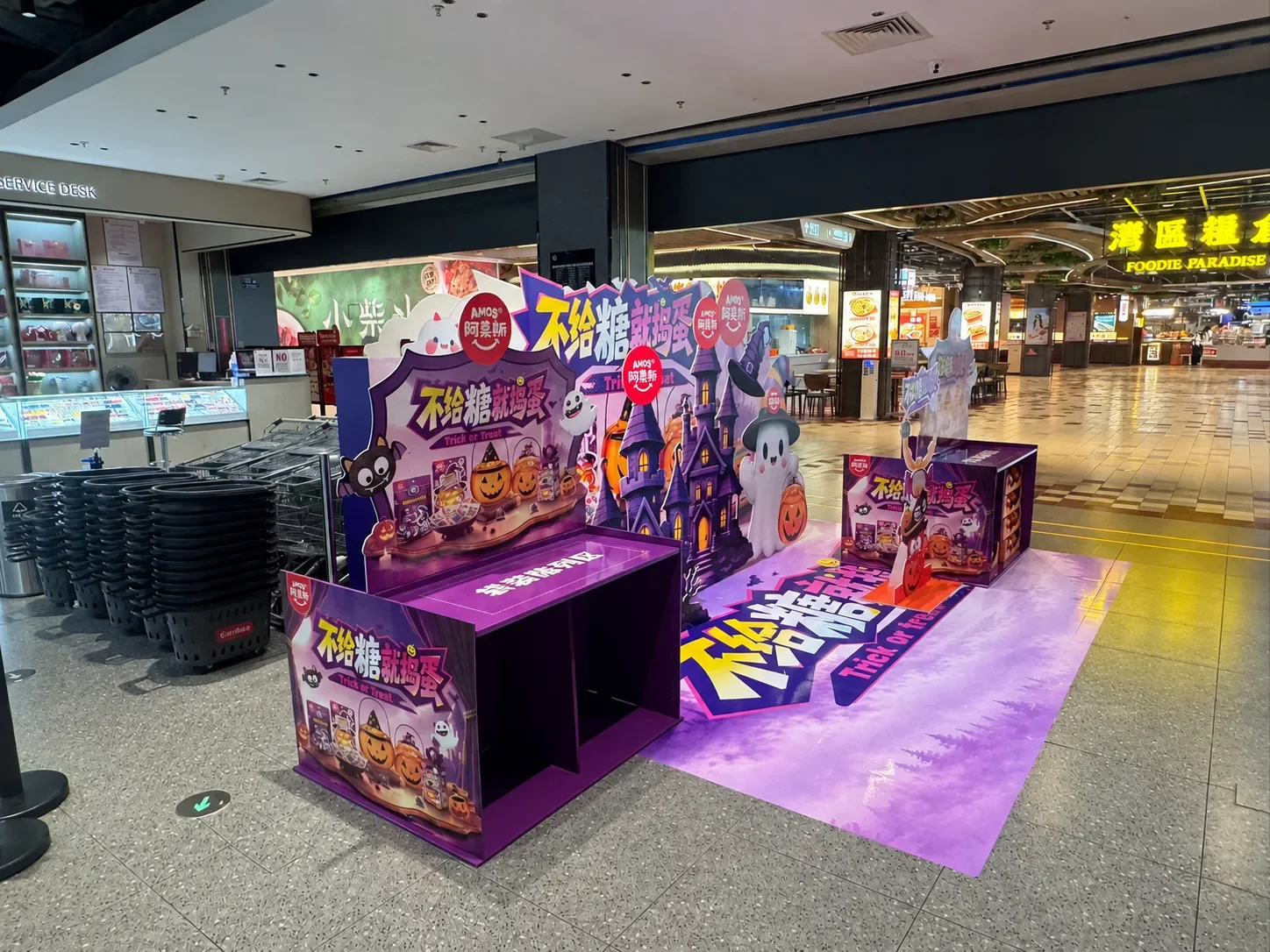 Front view of the Halloween promotion zone at a supermarket entrance with die-cut backdrops, display unit and purple floor graphic