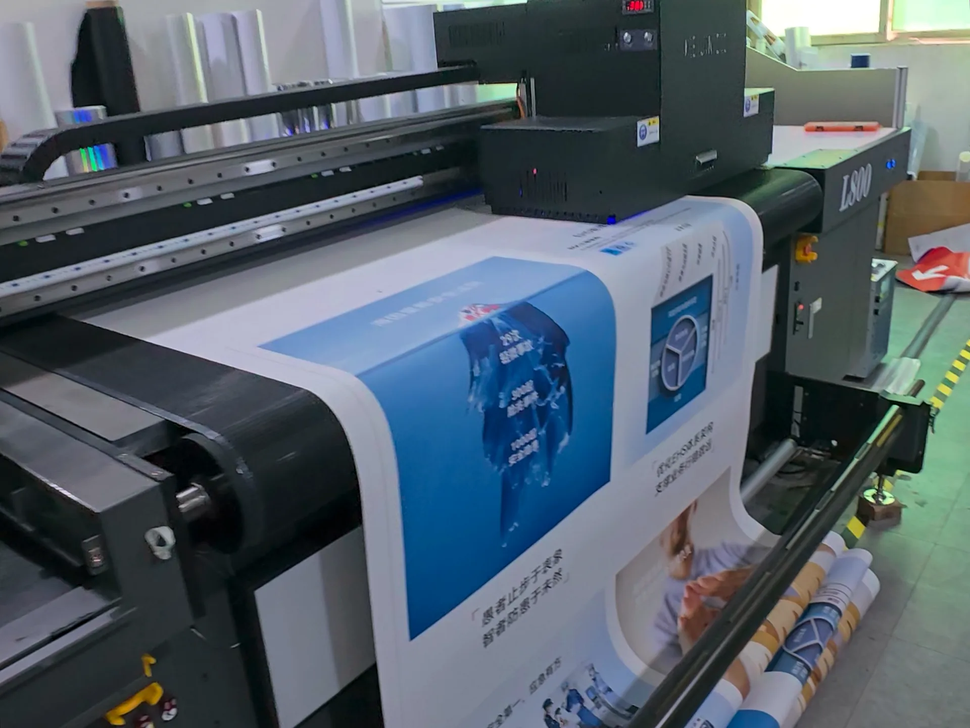 Printed blue graphics emerging from a roll printer