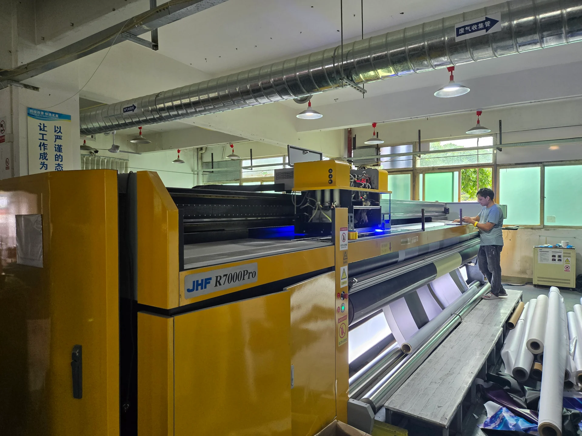 Operator beside a large-format printer in the Shenzhen workshop