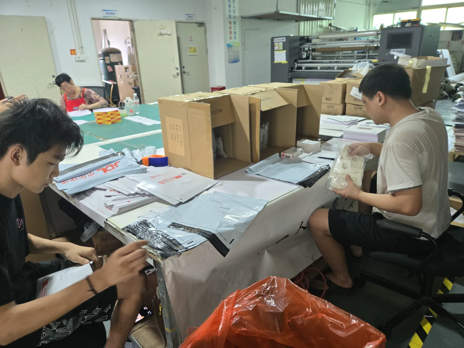 Workshop photograph: printed pieces and components being sorted and packed.