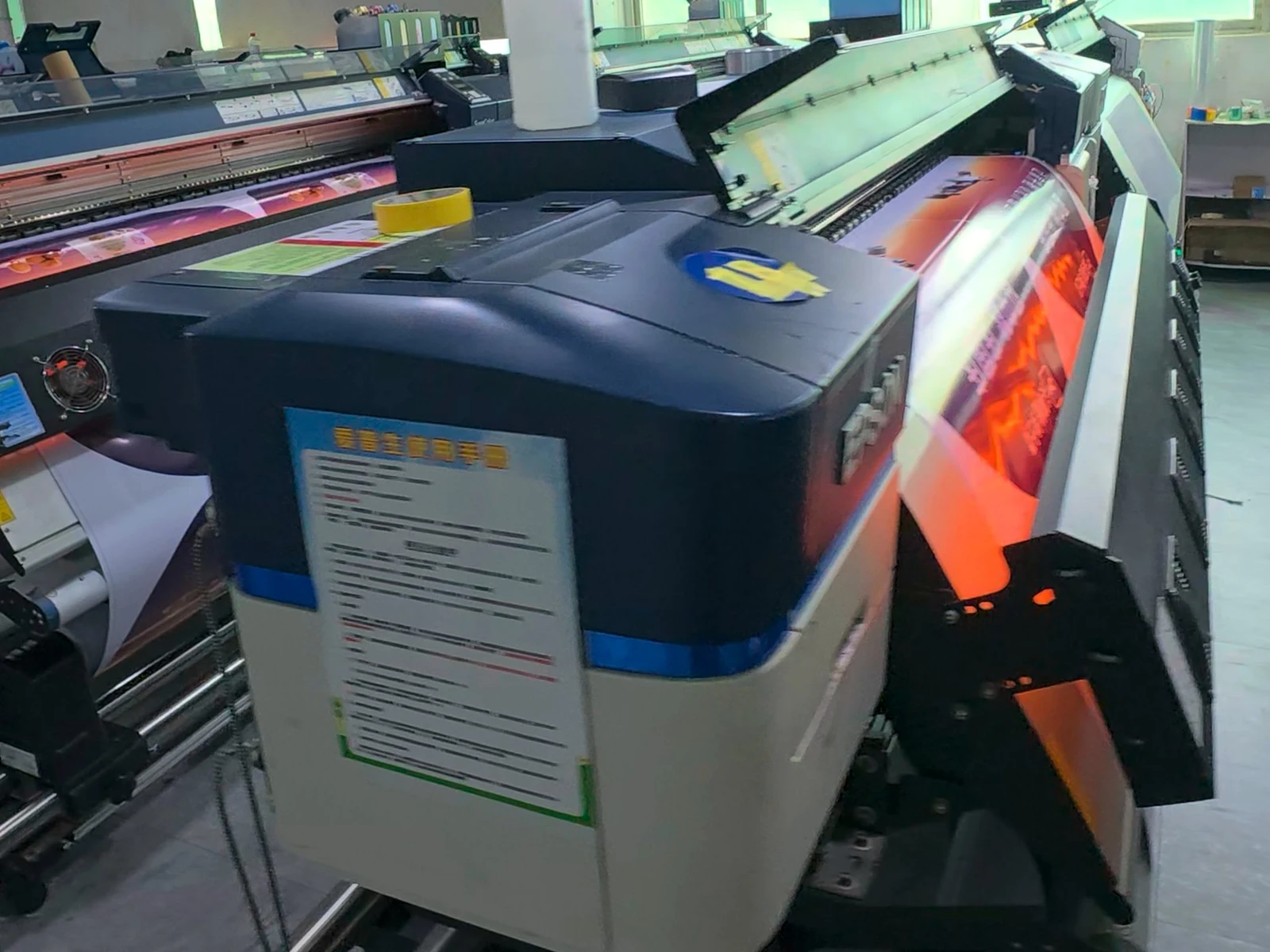 Workshop photograph: colour graphics coming off roll-fed printing equipment.